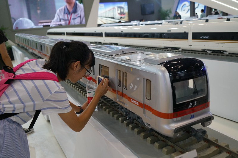 觀眾在拍攝中國中車展台上列車模型